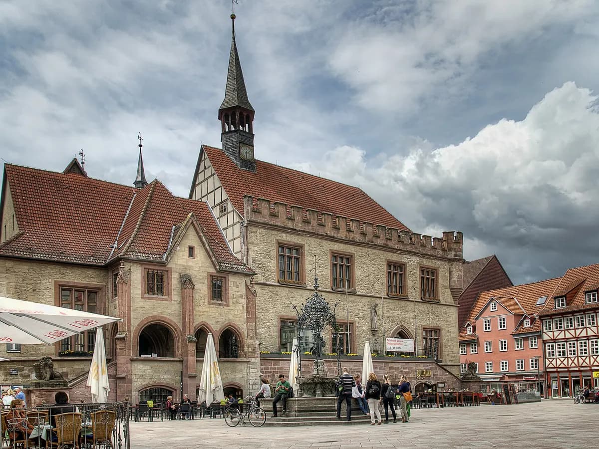 Göttingen: ein Brunnen mit bronzener Gänsehirtin vor einem spätgotischen Rathaus