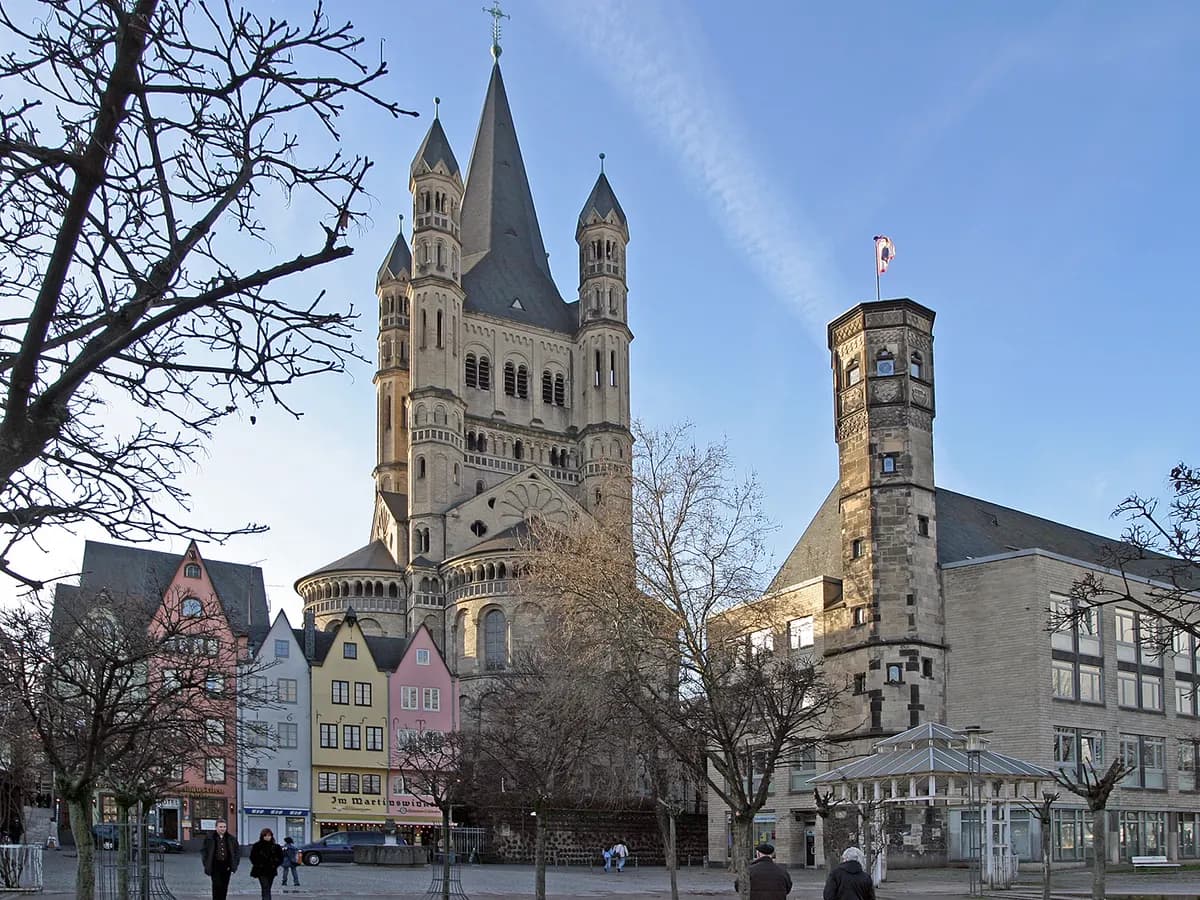 Köln: eine romanische Kirche mit Vierungsturm über den Giebelhäusern am Rhein