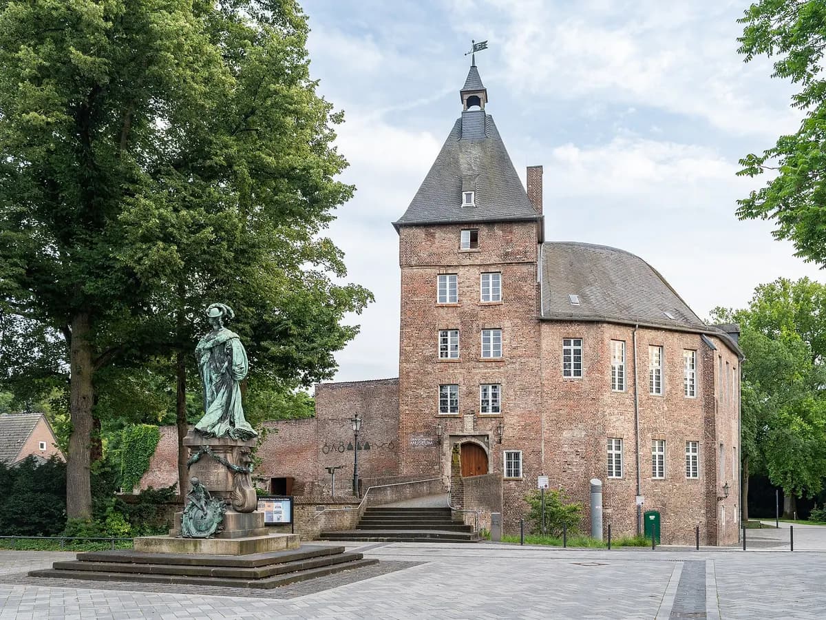 Moers: ein Renaissance-Schloss mit Wassergraben in einem Park