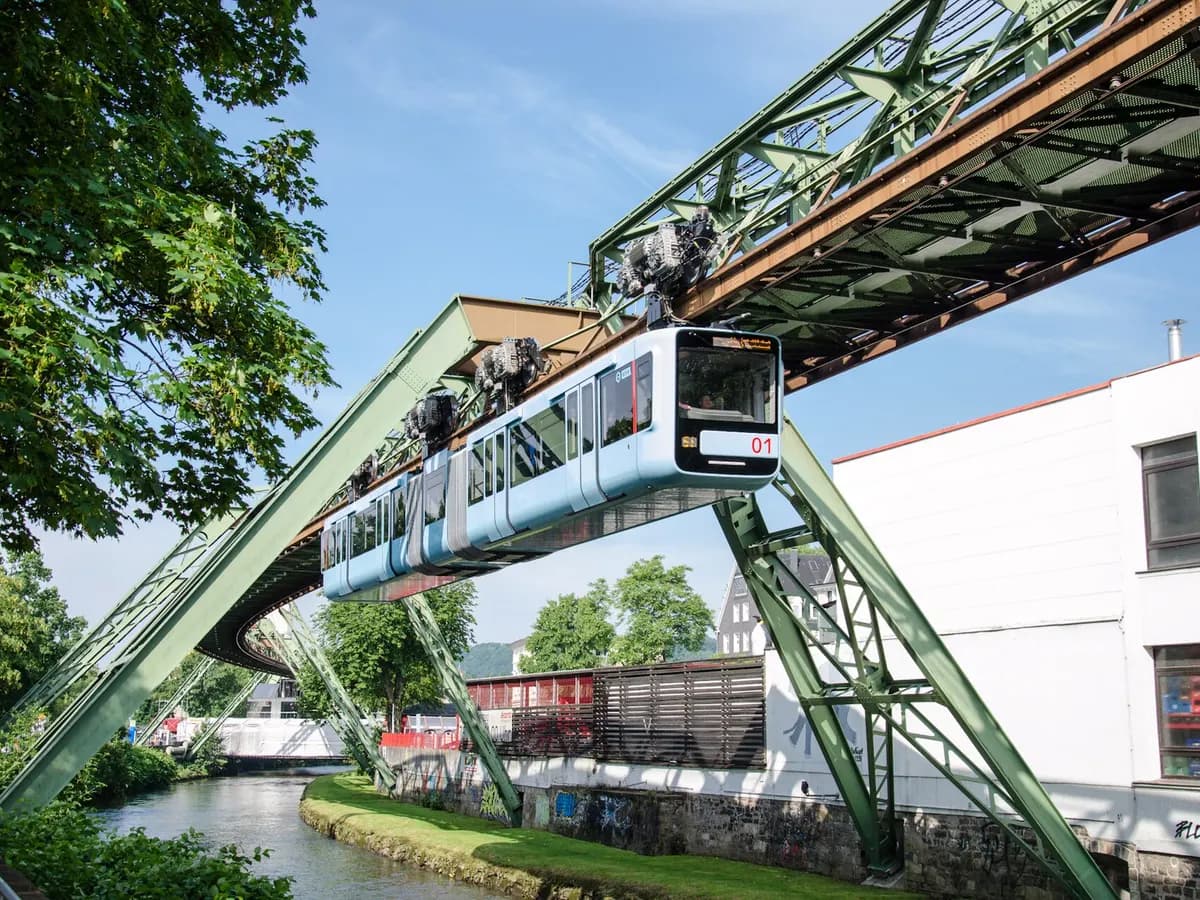 Wuppertal: eine Hängebahn auf Stahlgerüst über einem Fluss mitten in der Stadt