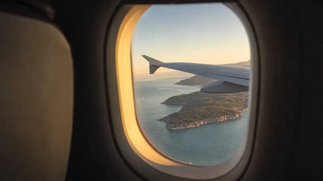 Der Blick auf die Mittelmeerküste aus einem Flugzeugfenster im Abendlicht