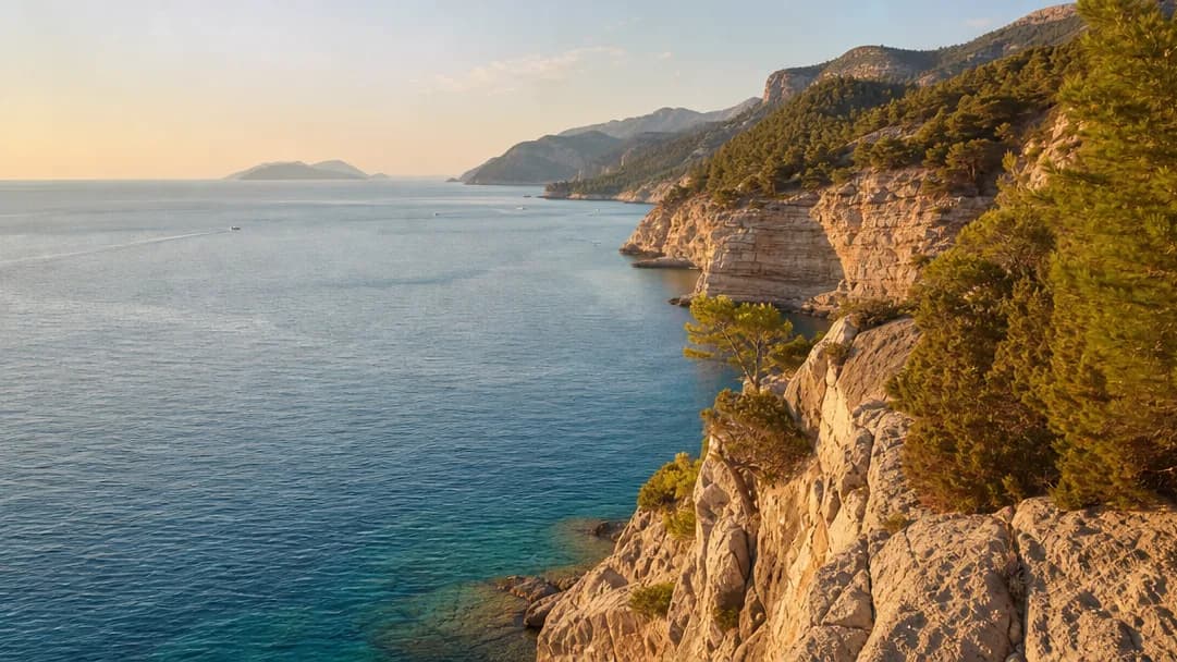 Die Küste von Antalya im Abendlicht, Felsen und türkisfarbenes Meer vor Pinienhügeln